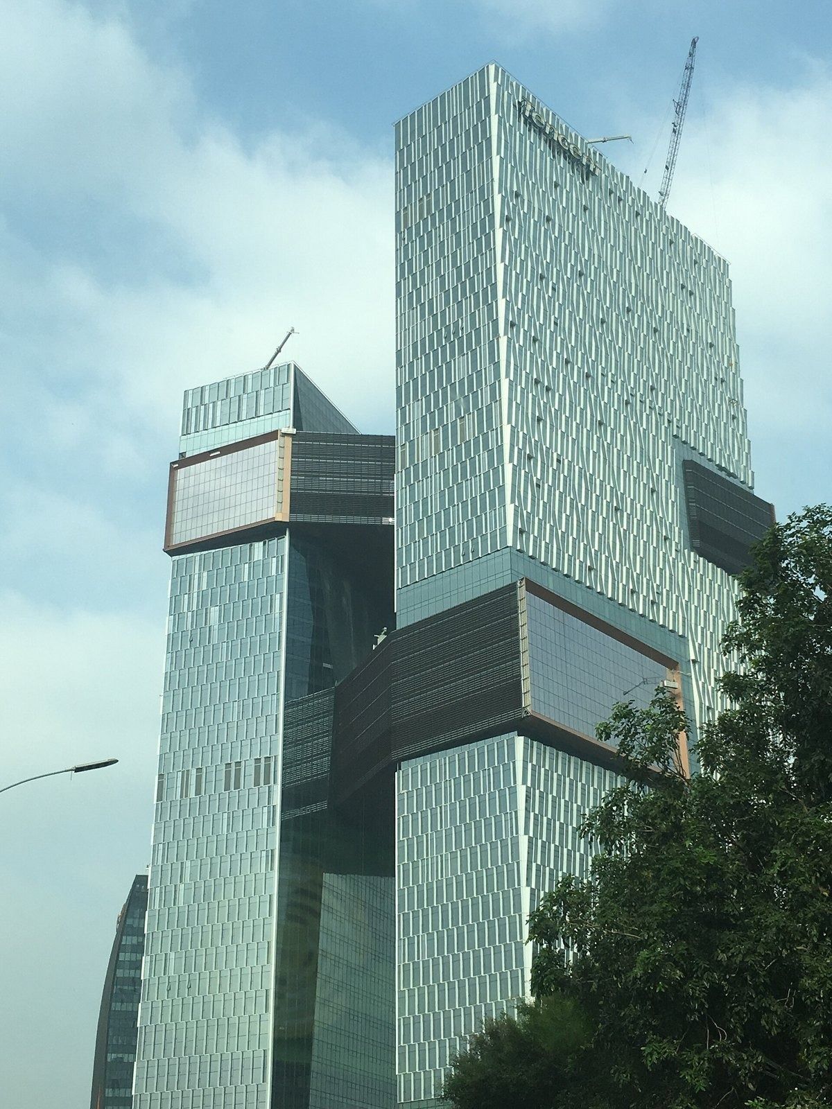 Tencent: Two glass towers against a pale sky, with bridges between