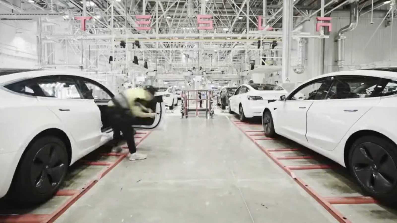 White cars on a bright assembly line