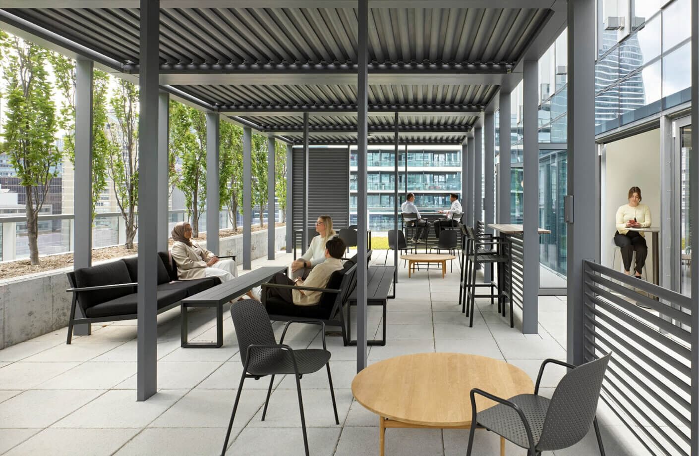 Thomson Reuters: A covered outdoor terrace with lounge chairs under a slatted metal roof