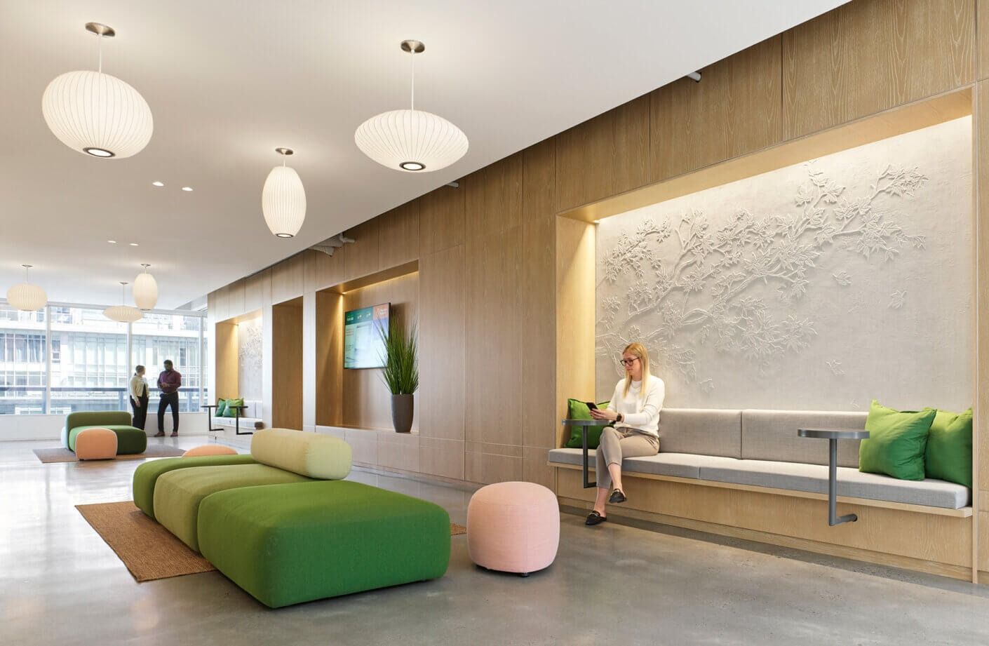 Thomson Reuters: A meeting room with long tables, grey chairs and a wood media wall