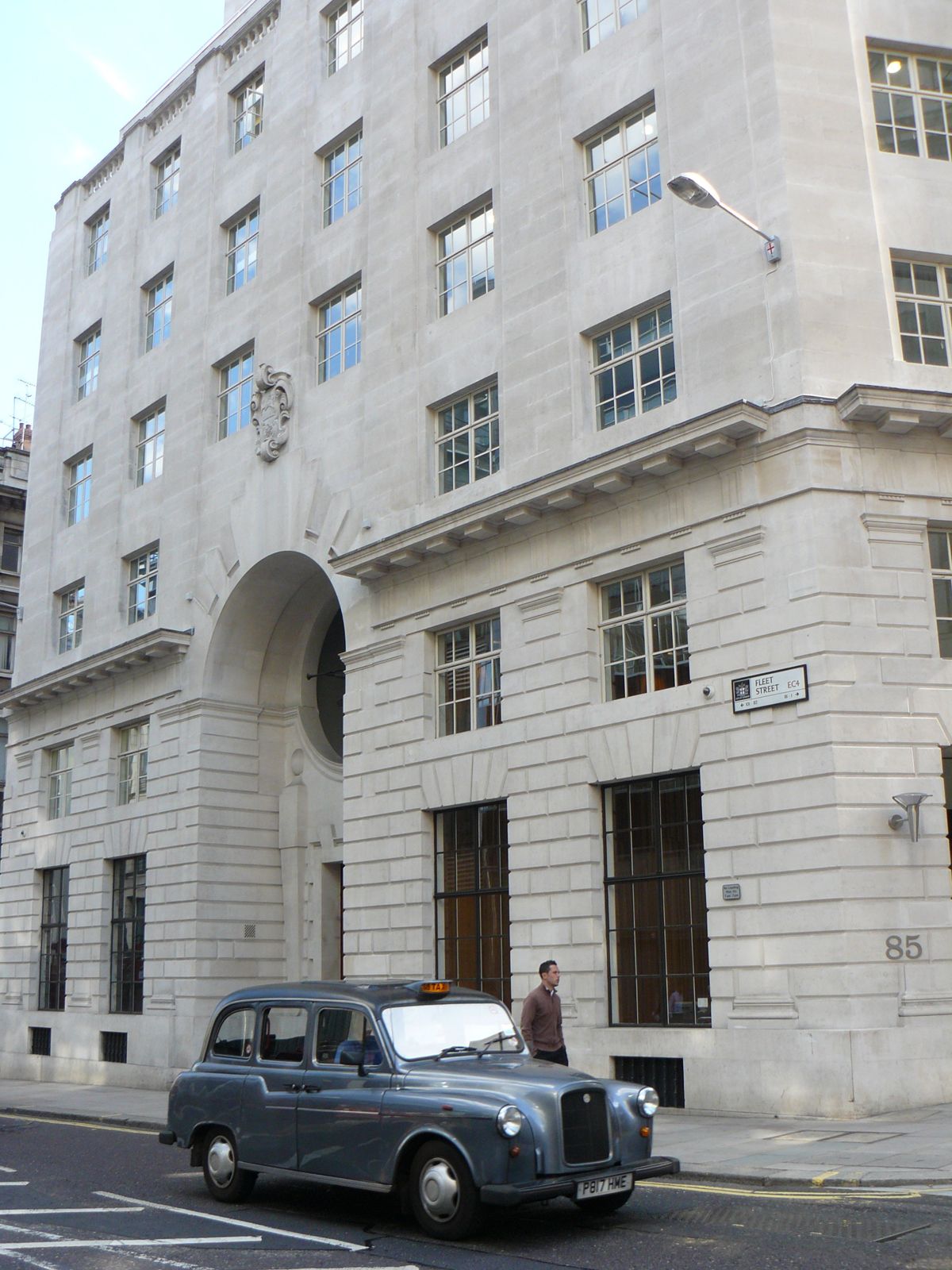 Thomson Reuters: A pale stone corner building with a black taxi in front