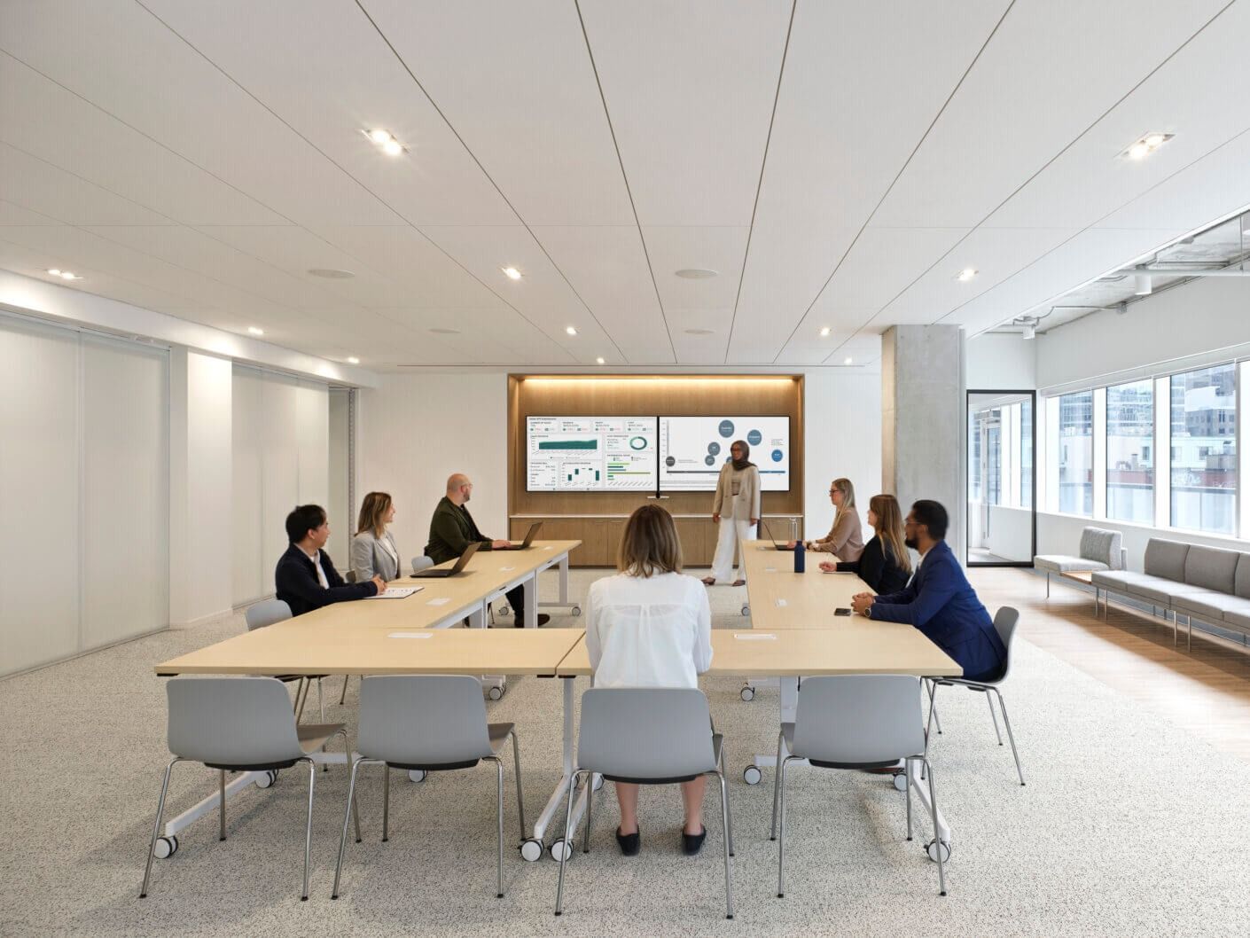 Thomson Reuters: Green and pink soft seating in front of a wood wall with a white relief panel