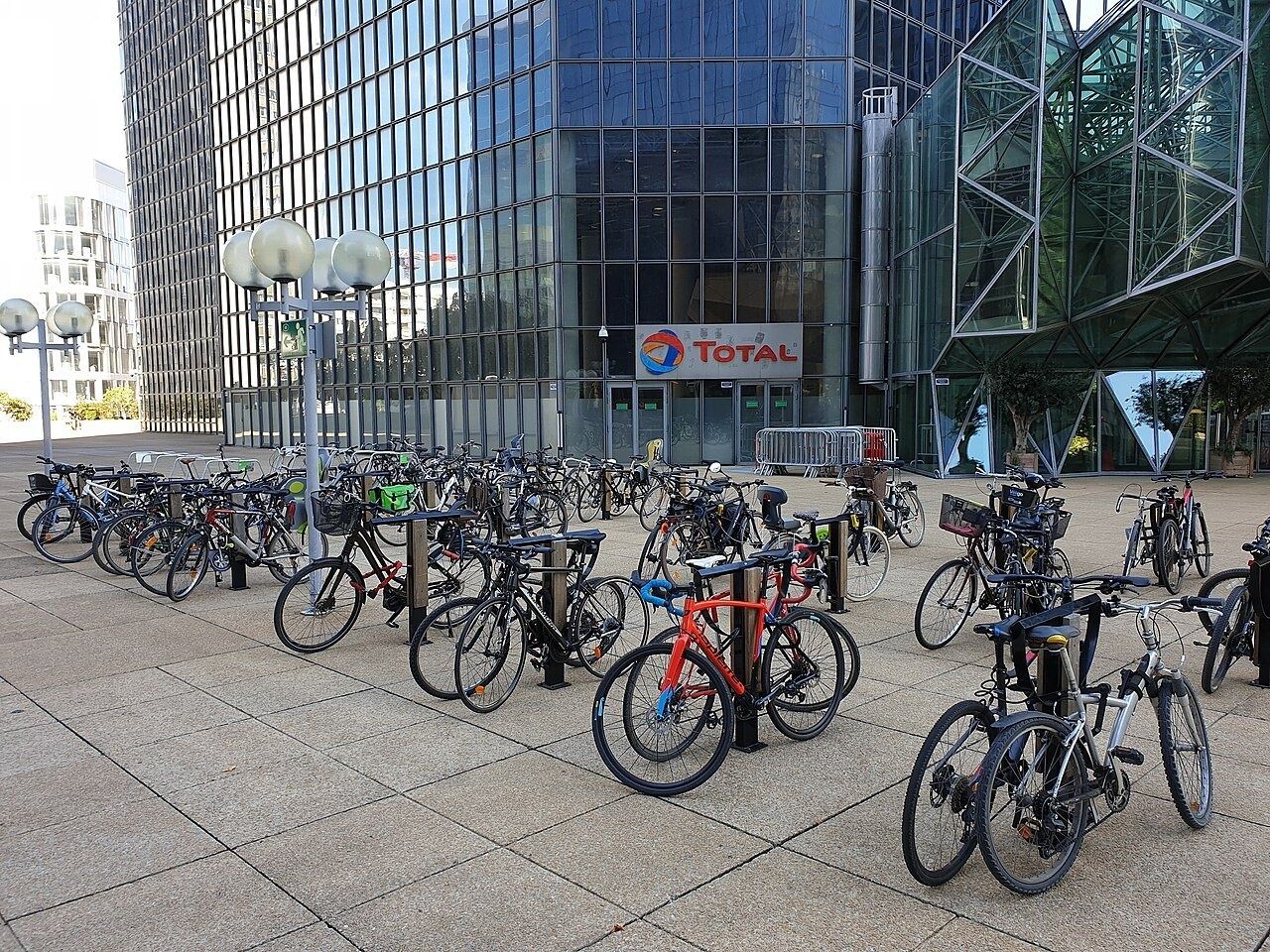 Bicycle racks in front of a glass tower with the Total sign