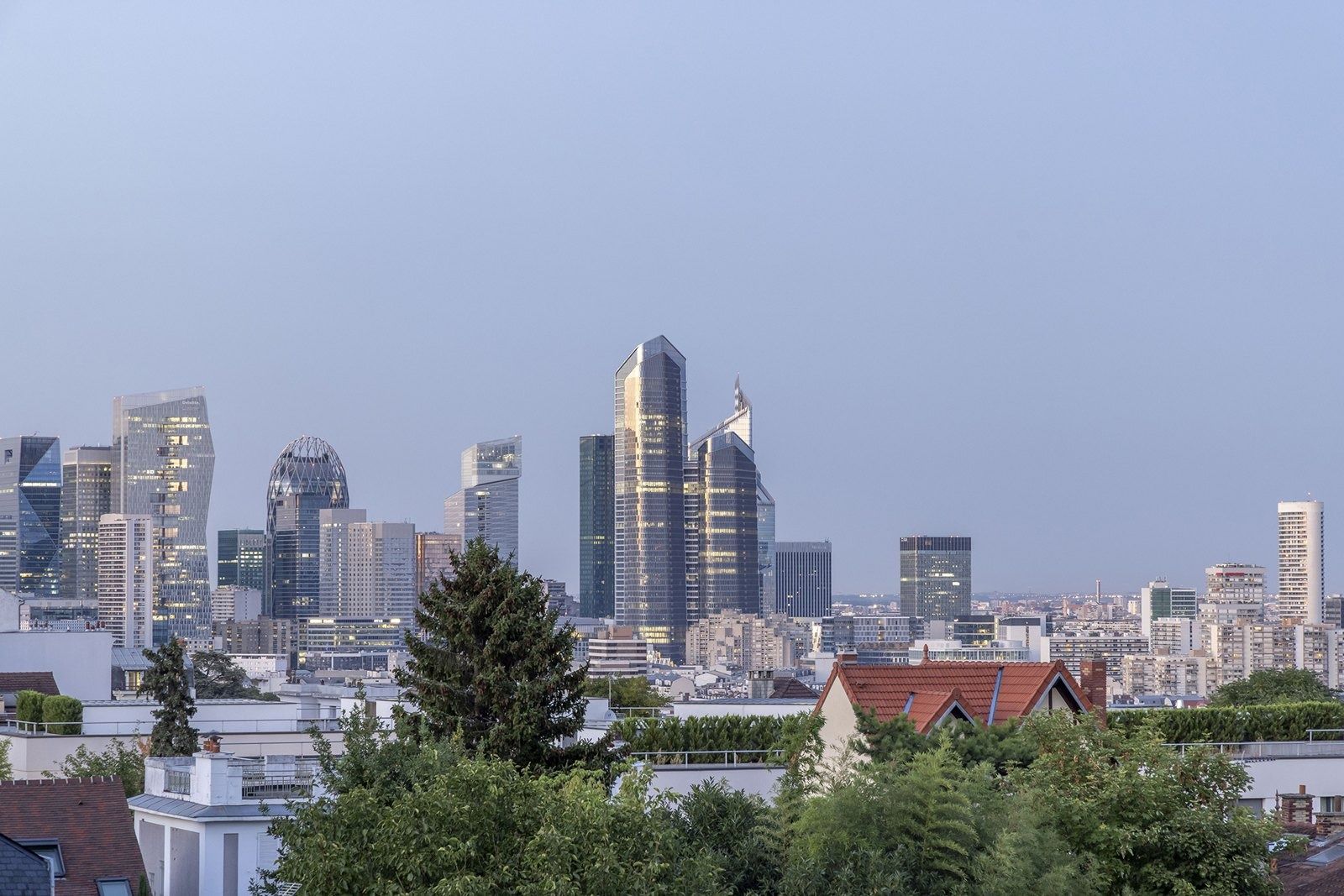 TotalEnergies: La Défense skyline beyond trees