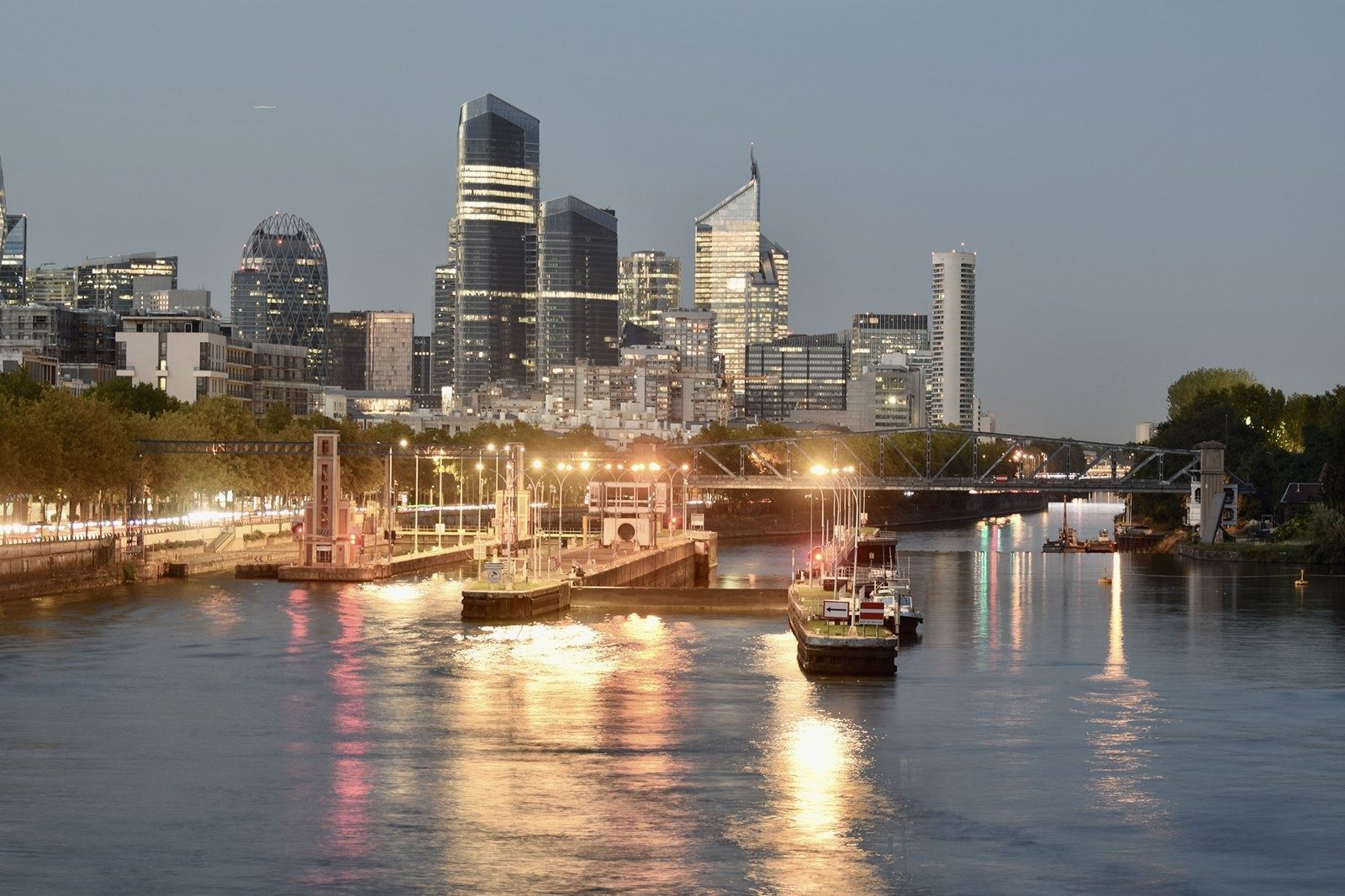 TotalEnergies: Lit towers reflected in the Seine at dusk