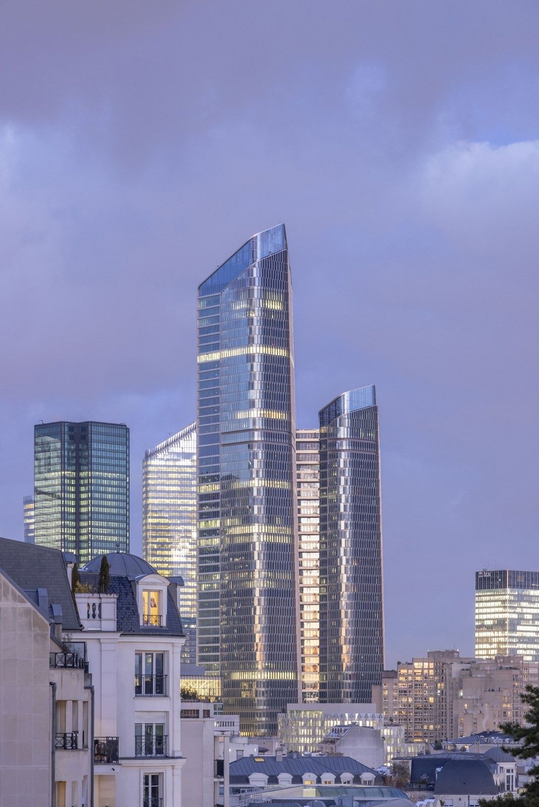 TotalEnergies: Two towers at dusk behind townhouses