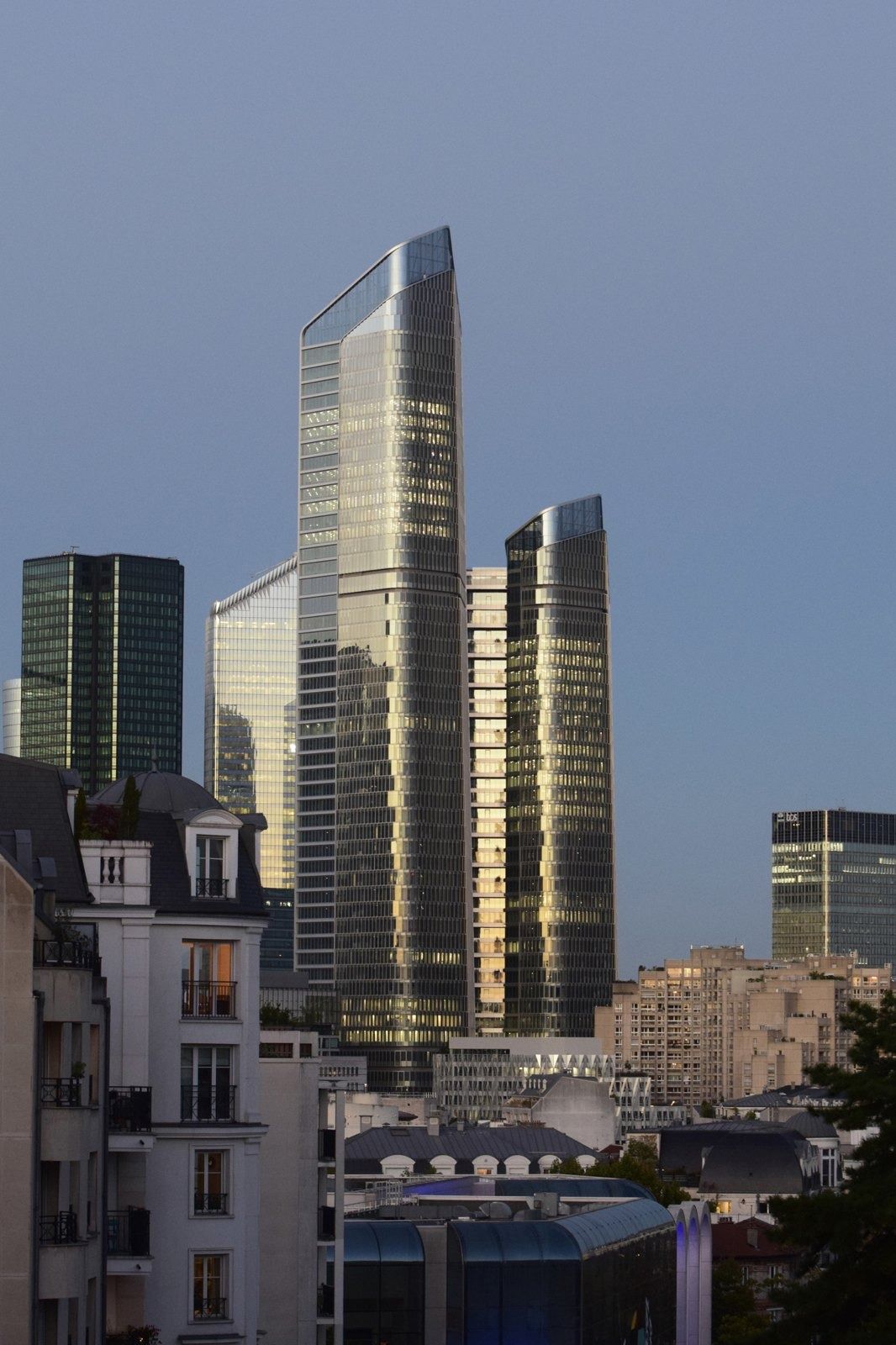 TotalEnergies: Two towers rising behind apartment buildings