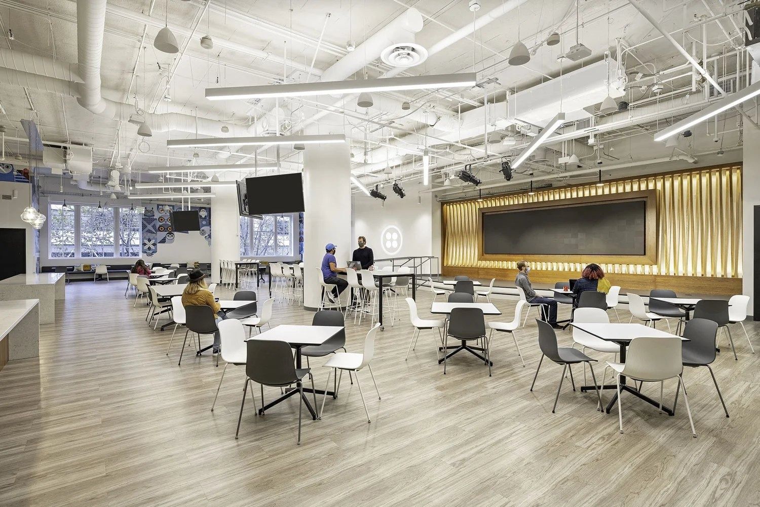 Twilio: Café seating in front of a lit timber wall
