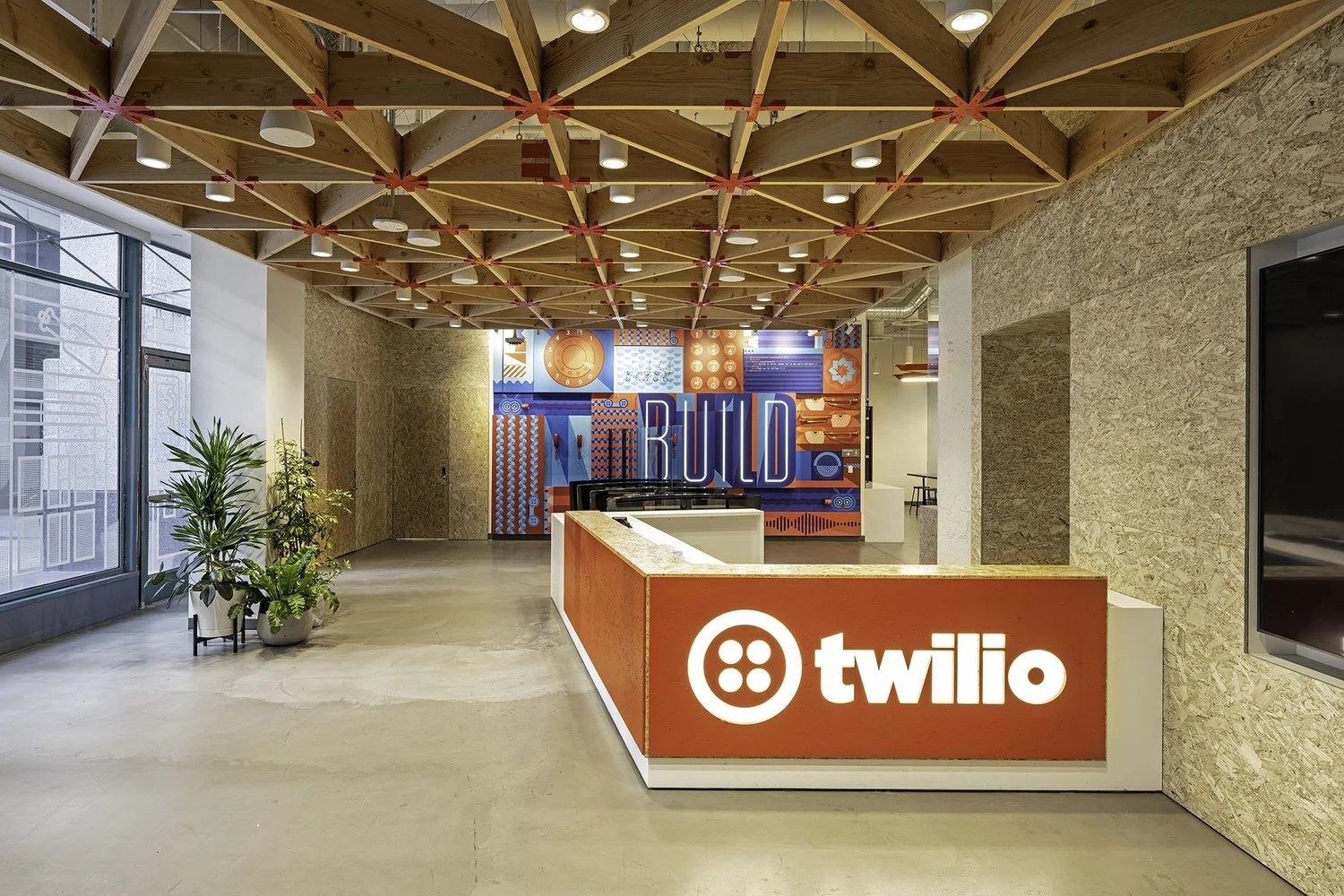 Reception desk with the Twilio logo under a timber lattice ceiling