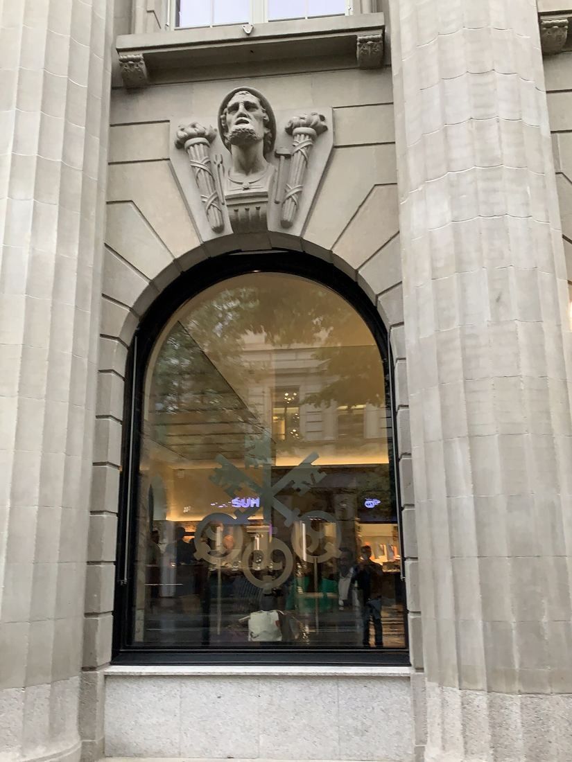 UBS: Tall arched window between two fluted columns with a carved head above