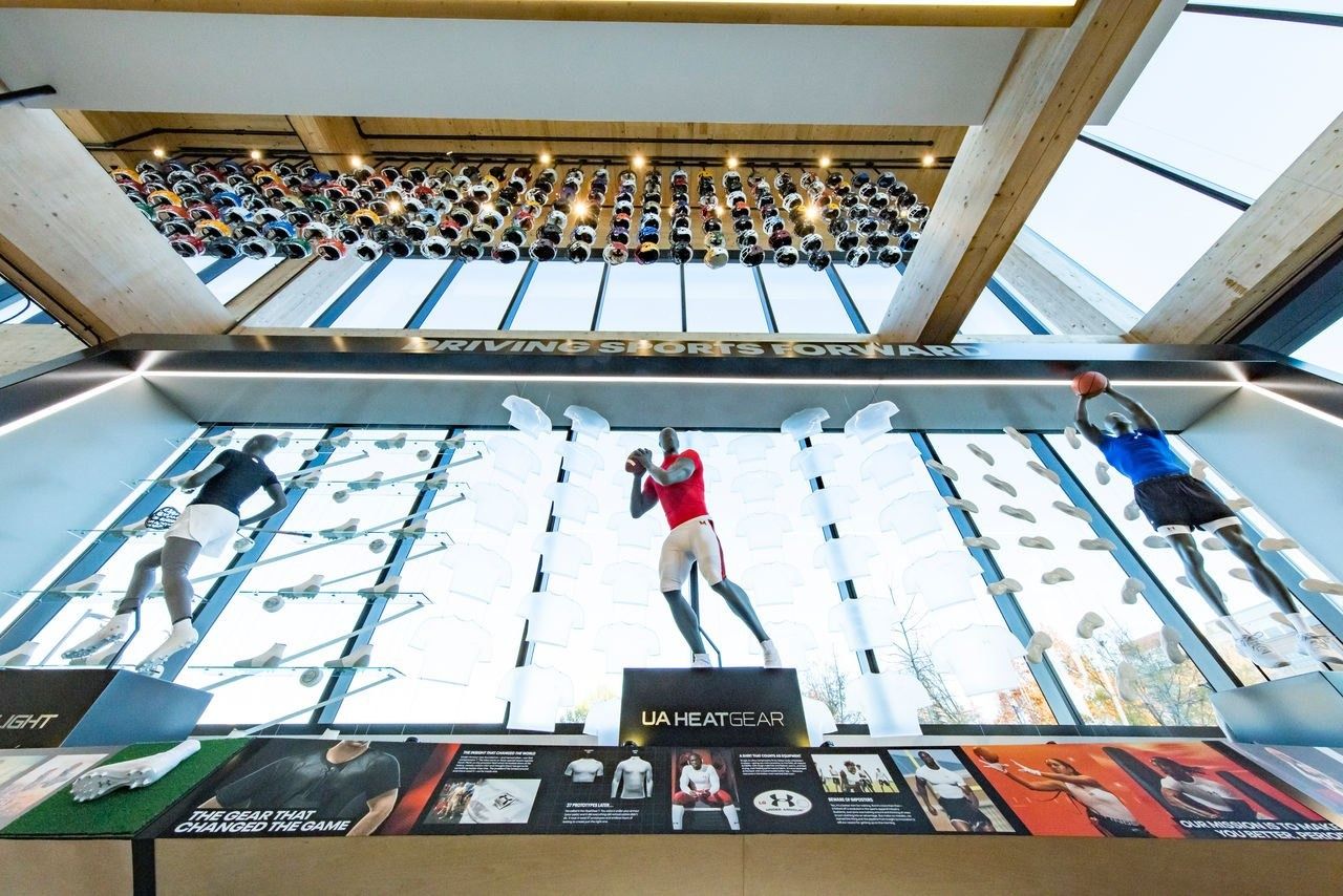 Under Armour: Bright wall display with mannequins in motion poses under a skylight