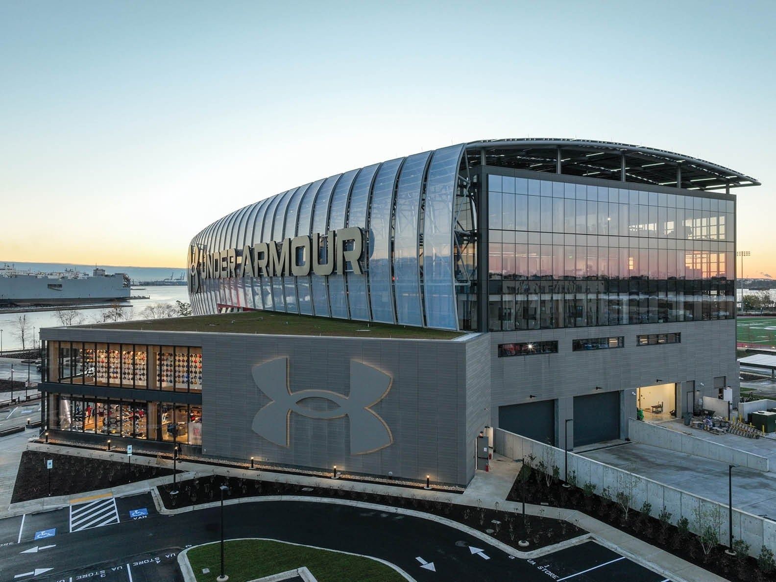 Under Armour: Elevated view of the building with its curved metal-and-glass crown and a green roof terrace at sunset