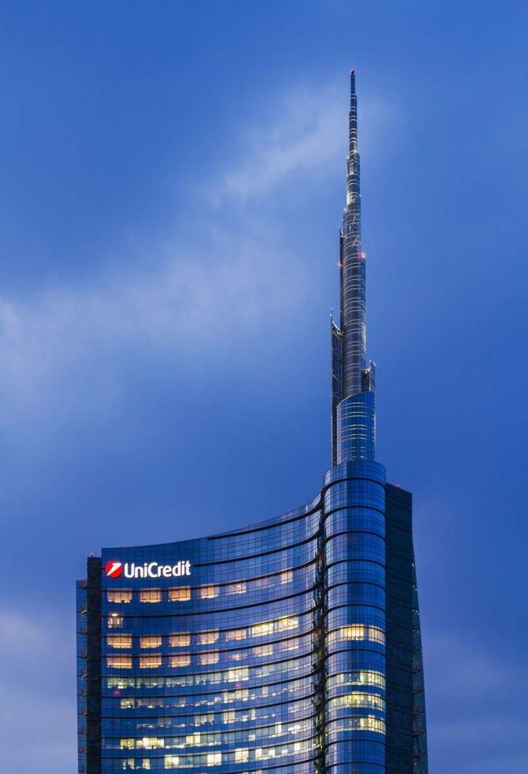 UniCredit: Glass tower topped by a slender spire against a blue sky