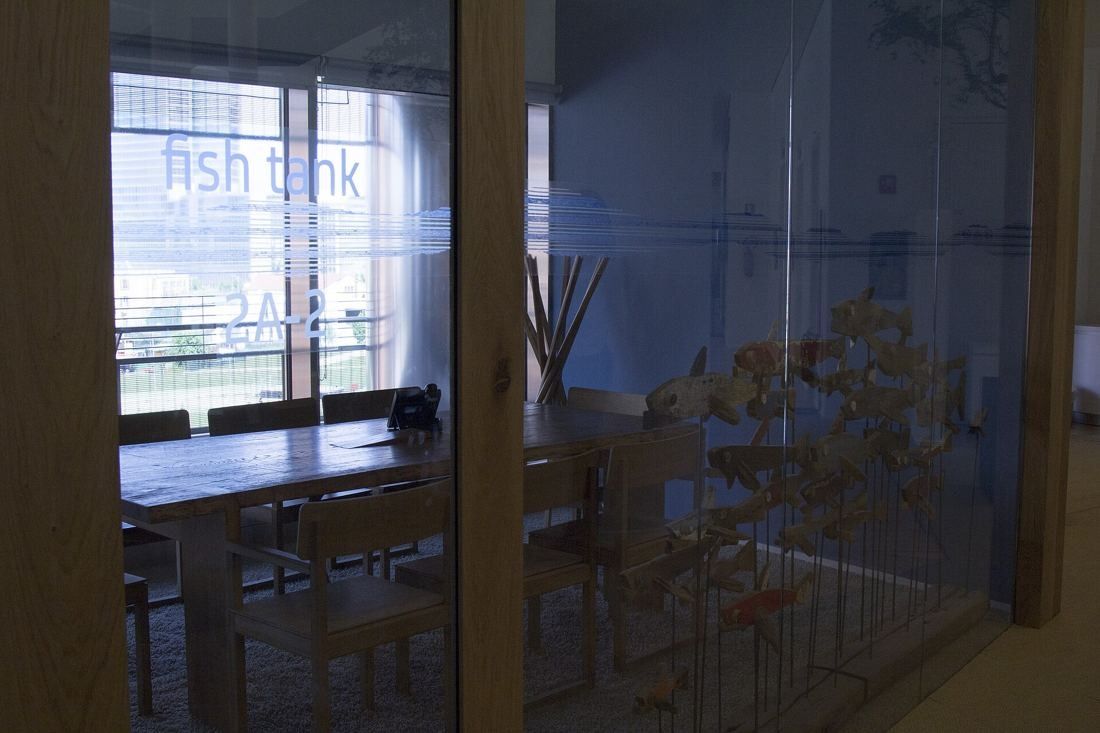 UniCredit: Glass-walled meeting room with a wooden table and chairs