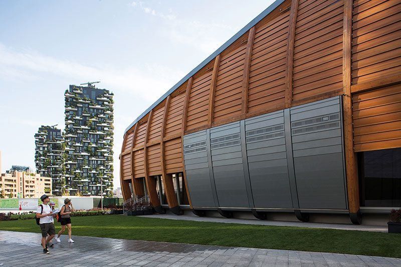 UniCredit: Long timber-clad building with metal panels beside a lawn and a planted residential tower