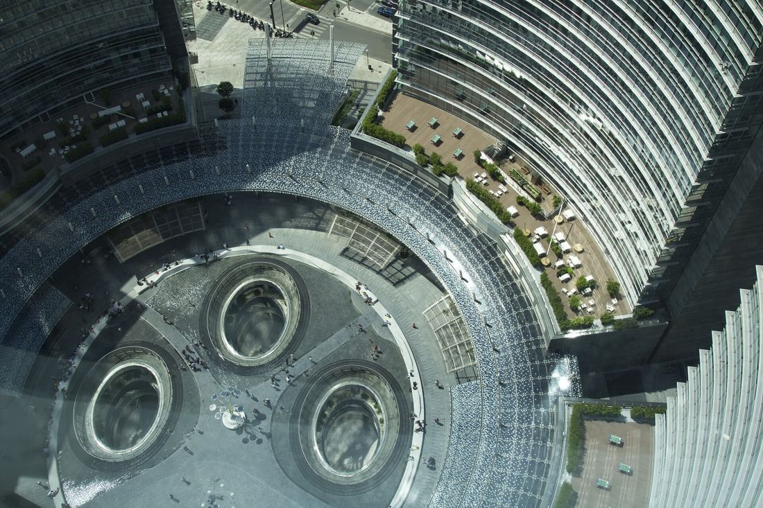 UniCredit: Looking straight down from a curved glass tower onto a round plaza with three circular openings
