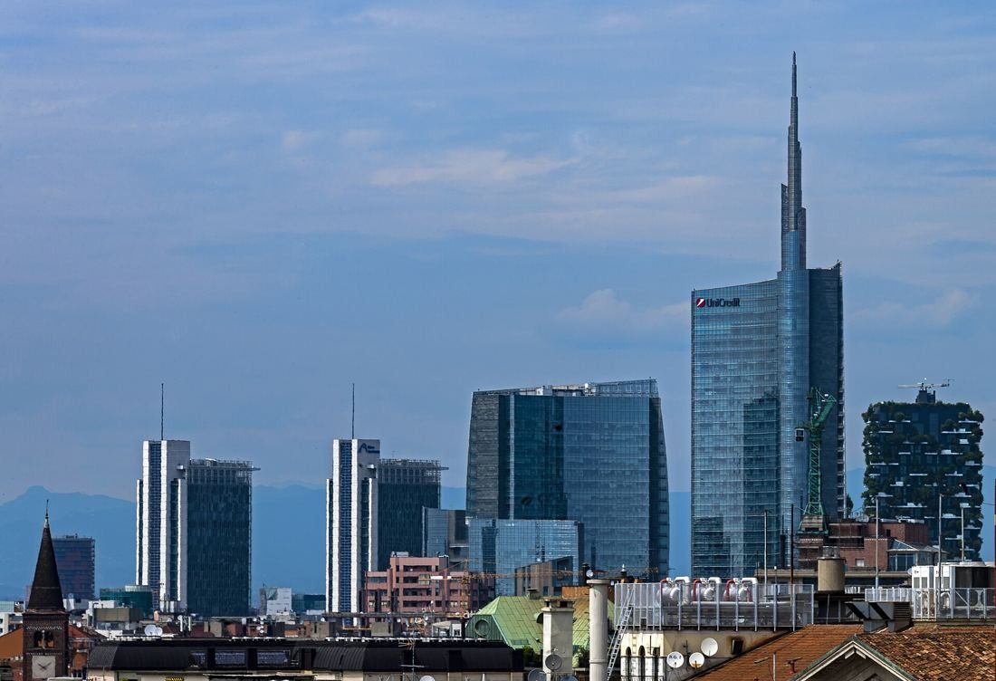 UniCredit: Milan skyline with the spired tower and other high-rises behind older roofs