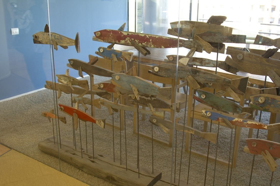 UniCredit: Sculpture of many wooden fish on rods in a bright room