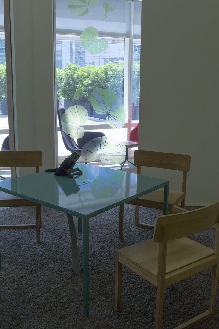 UniCredit: Small teal table with wooden chairs by a window with leaf-pattern decals