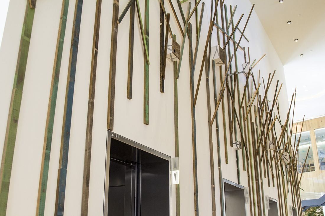 UniCredit: White interior wall with slender wooden branch-like sticks around a doorway