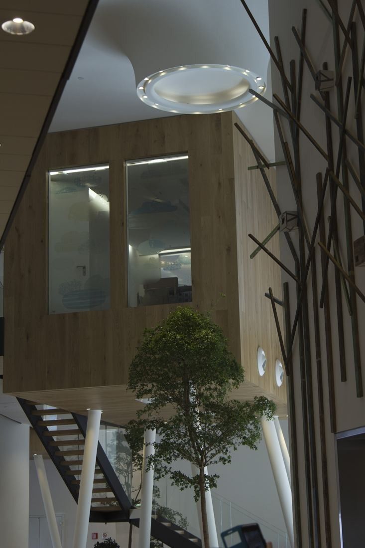 UniCredit: Wooden box-like room with a window, tree-branch decoration and a staircase