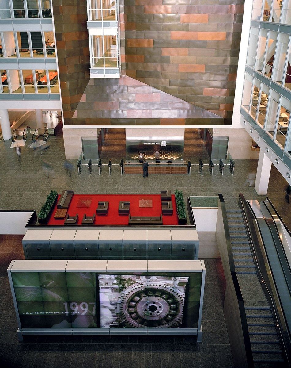 Union Pacific: Looking down on an atrium floor with a red seating area and escalators