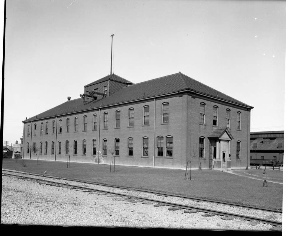 Old photo of a two-story brick building beside railroad tracks