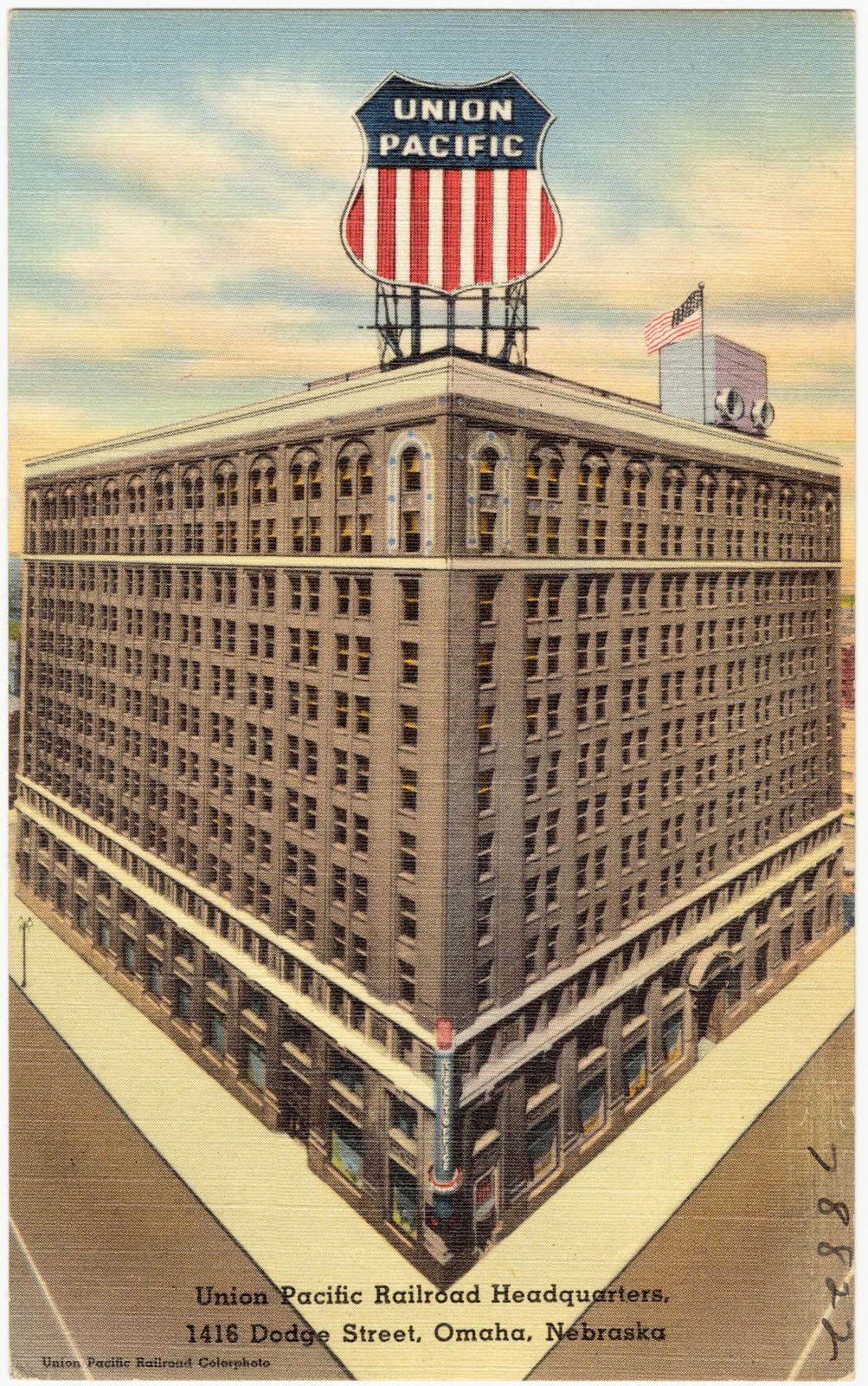Postcard of a large brick office building with a Union Pacific shield sign on the roof
