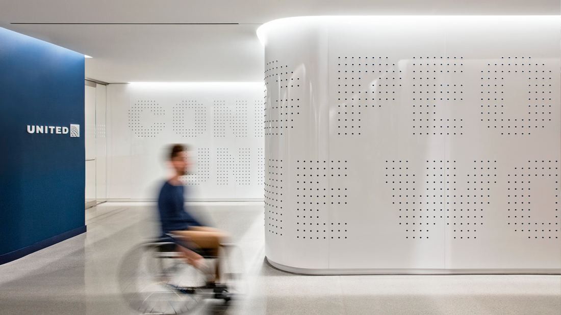 United Airlines: Curved white perforated wall beside a blue wall with a UNITED sign