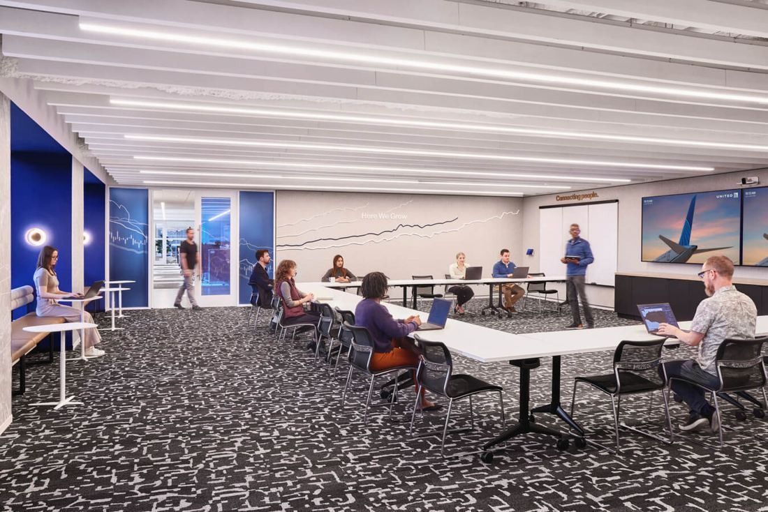 United Airlines: Long training room with tables in rows and screens on the walls