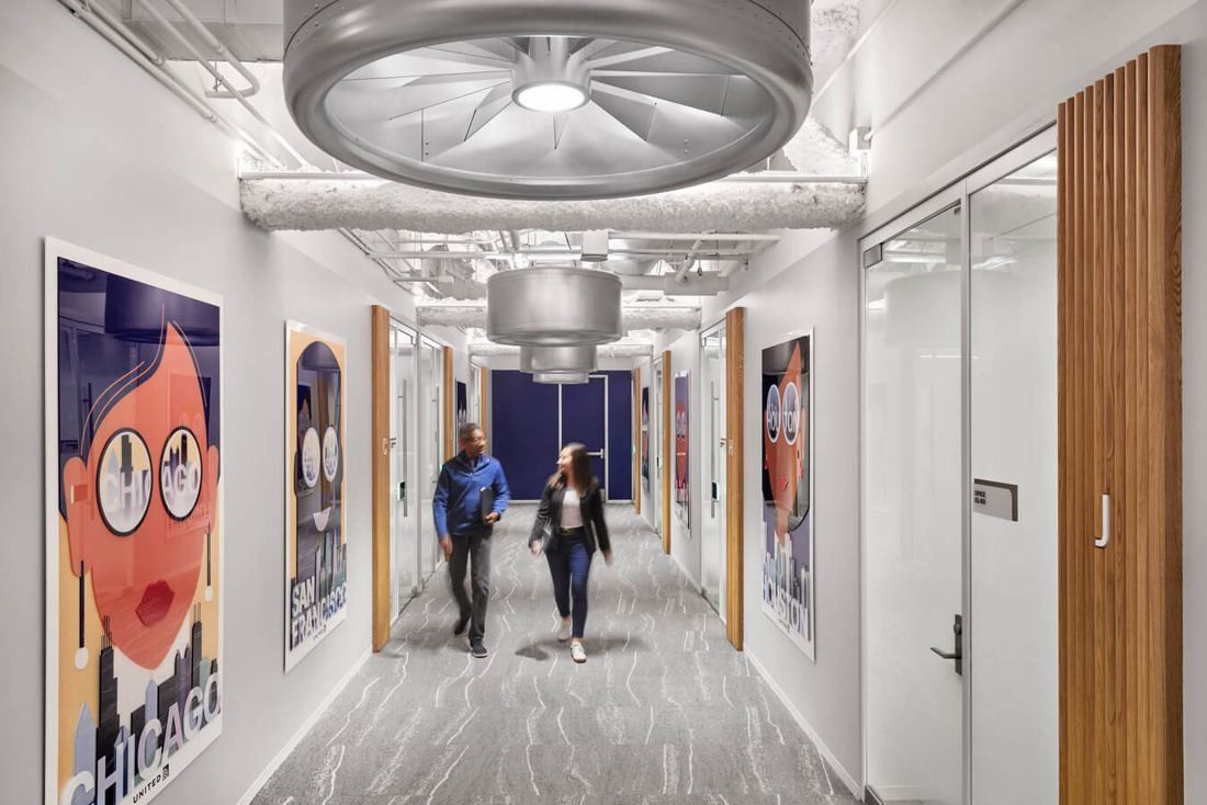 United Airlines: Office corridor with large metal engine-fan light fixtures and city posters on the walls
