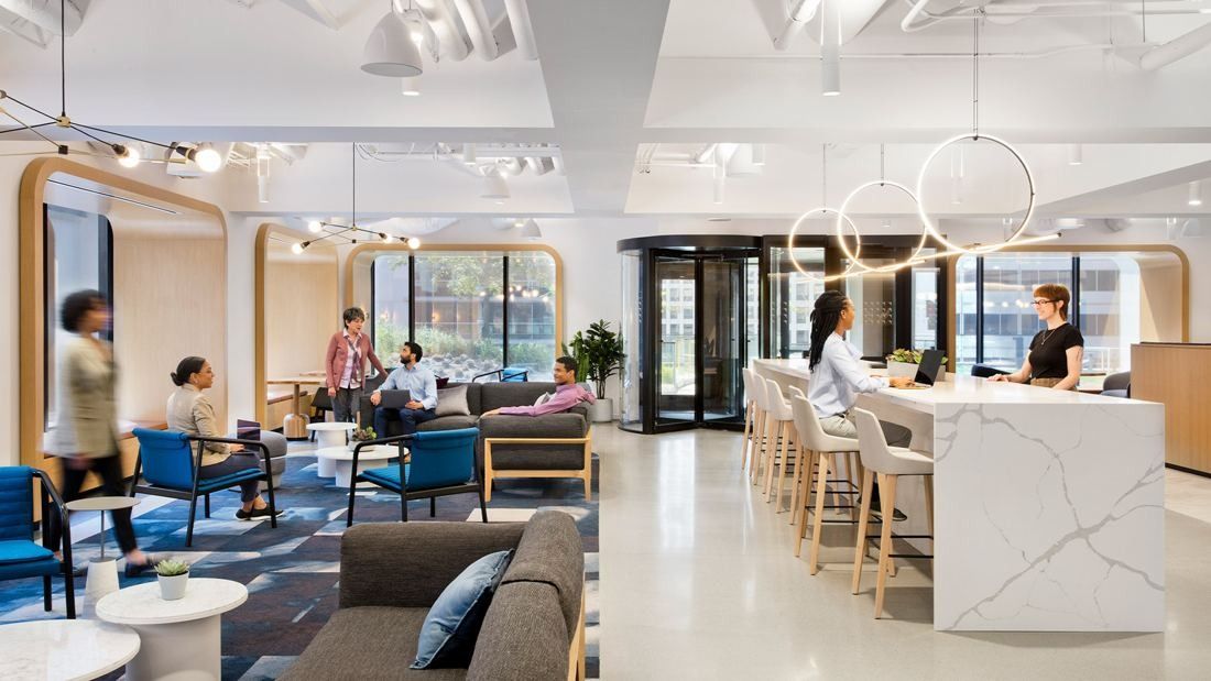 United Airlines: Open lounge with sofas, a marble counter and round pendant lights by the windows