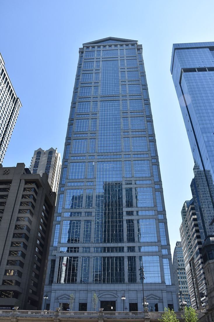 Slender glass skyscraper with a pointed top against a blue sky