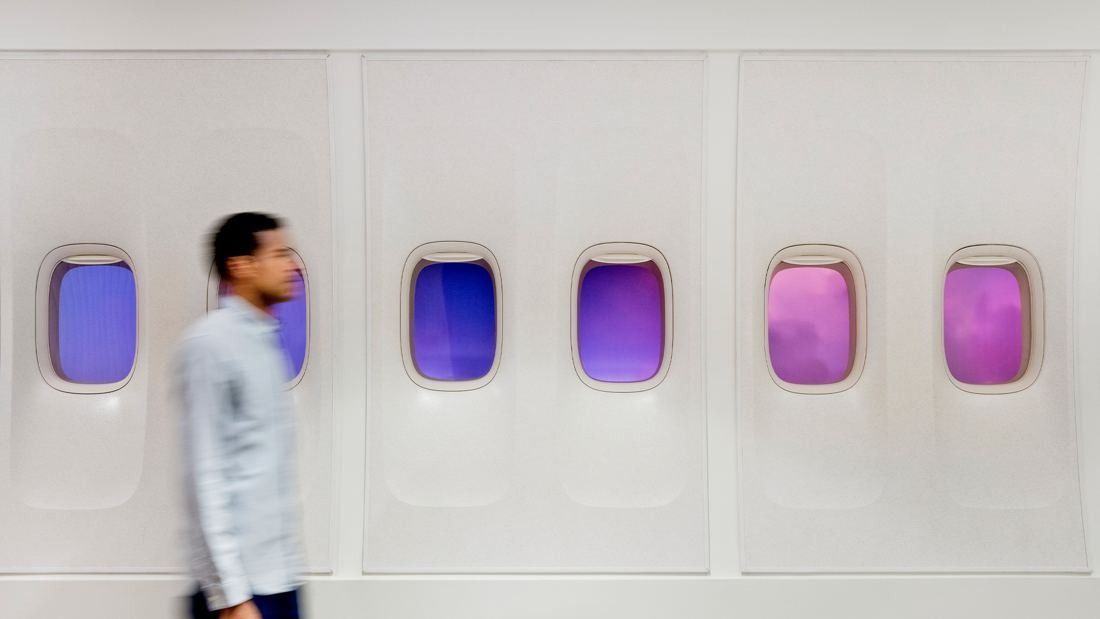 United Airlines: White wall with a row of aircraft-style windows lit in purple and pink