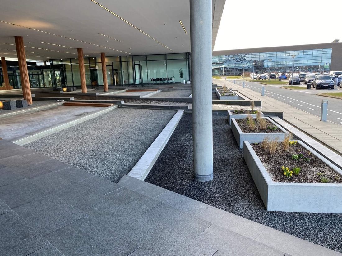 Vestas: Covered forecourt with concrete planters, gravel beds and a car park beyond