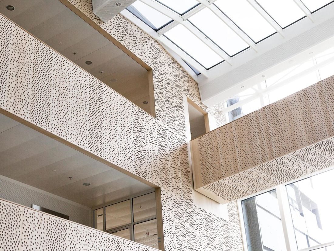 Vestas: Looking up past perforated light-wood balustrades to a skylight roof