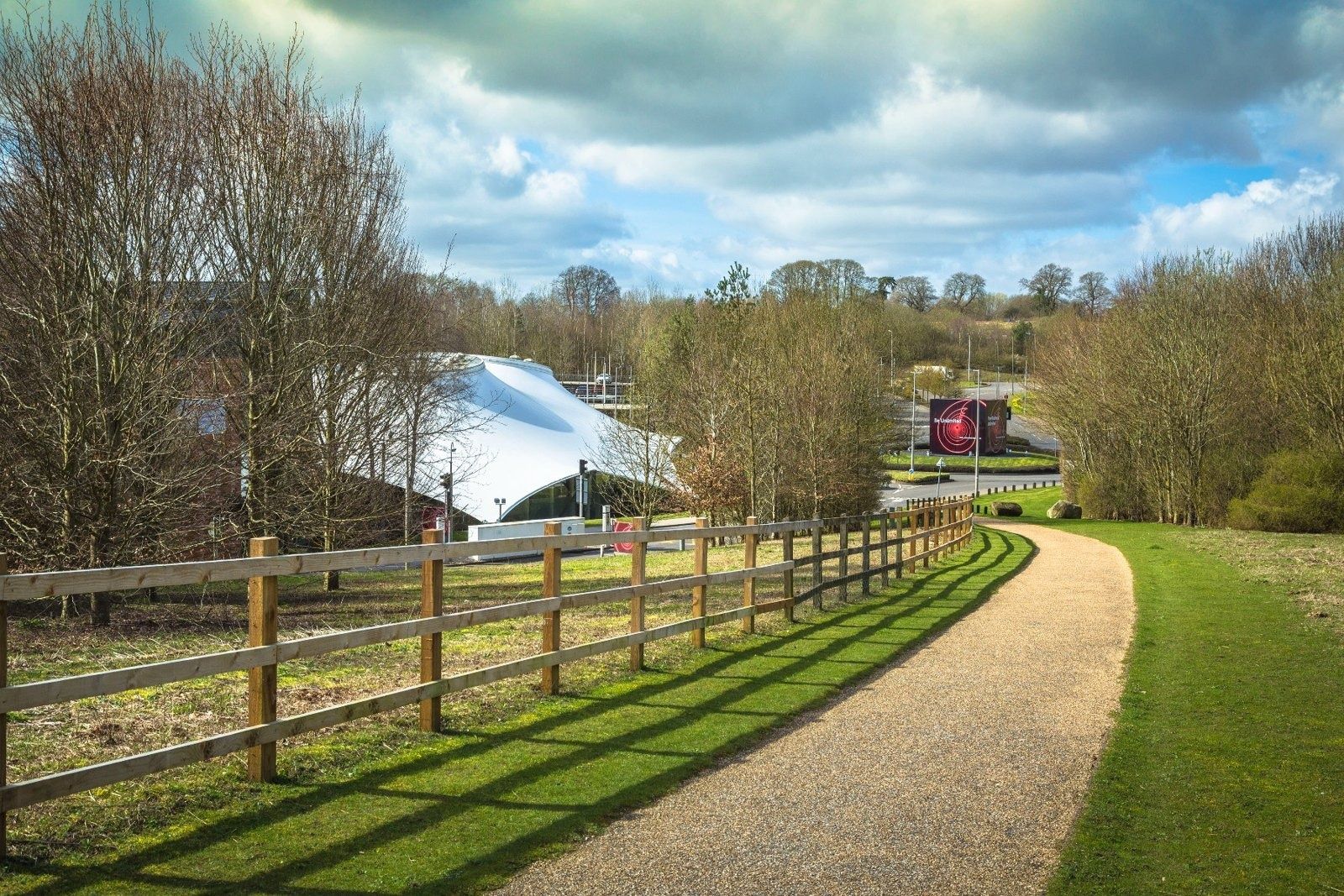 Vodafone: Gravel path with a wooden fence leading toward the white fabric pavilion