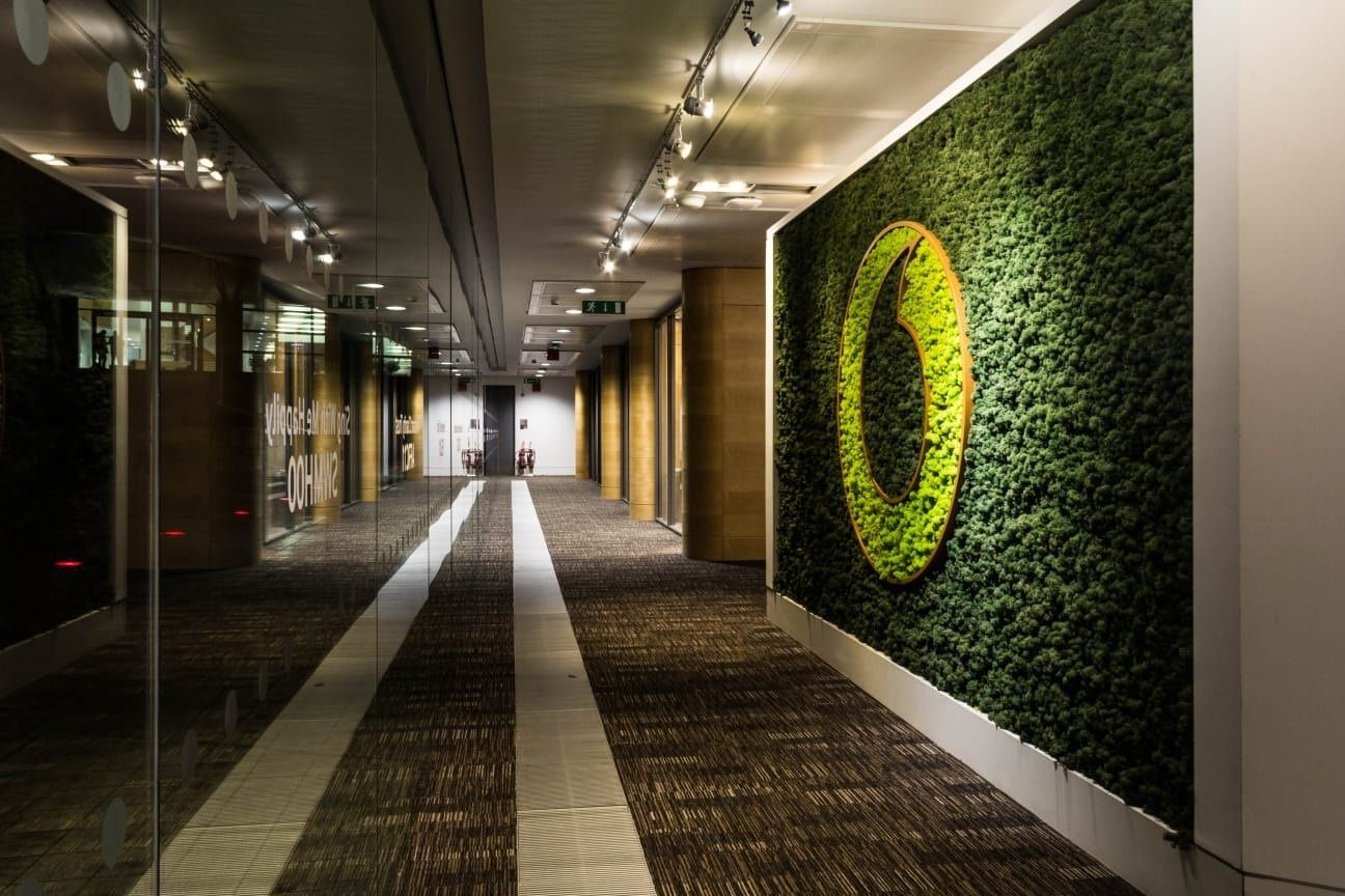Vodafone: Long corridor with a green moss wall bearing a speech-mark emblem