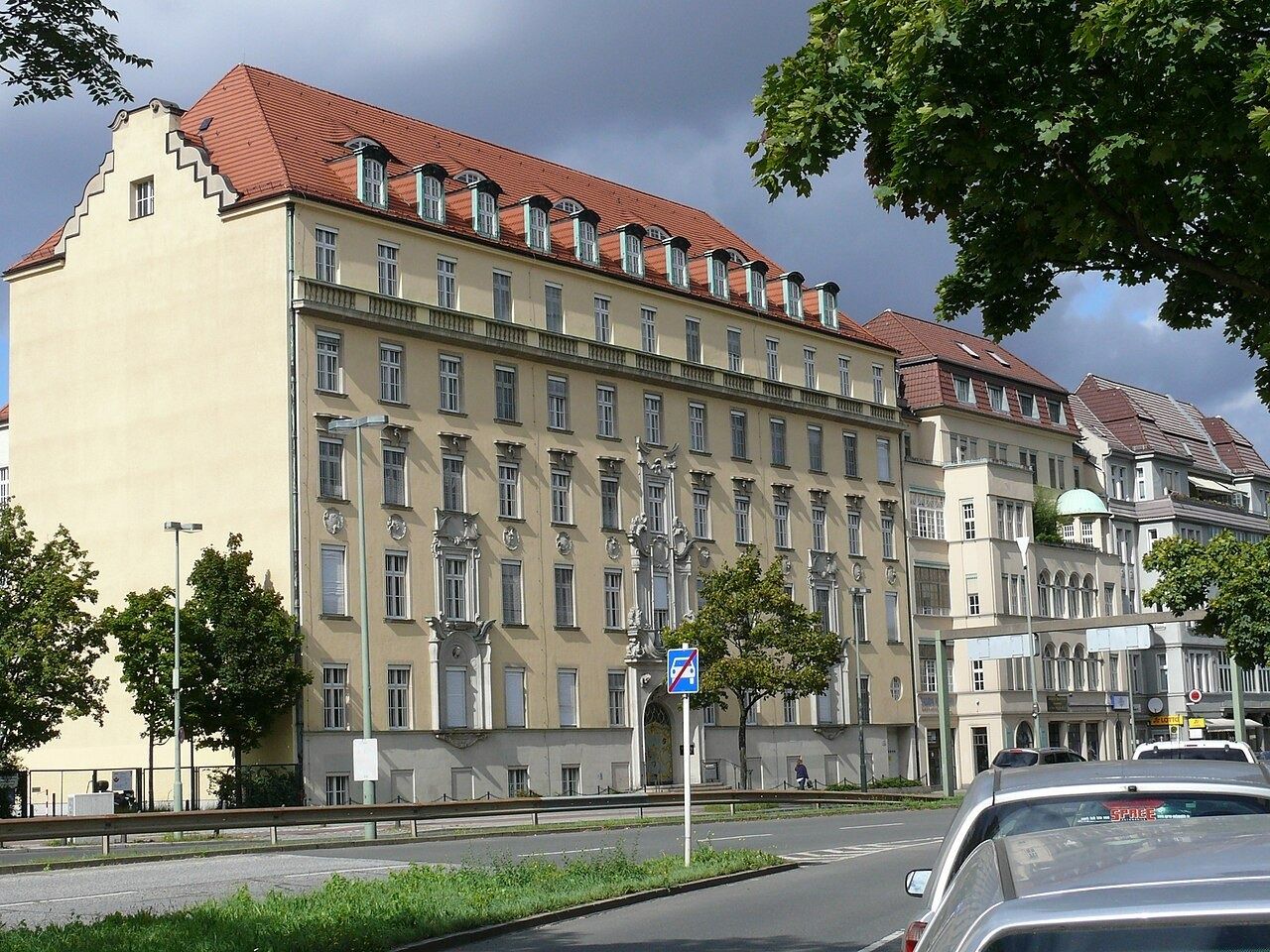 Large yellow building on a tree-lined avenue