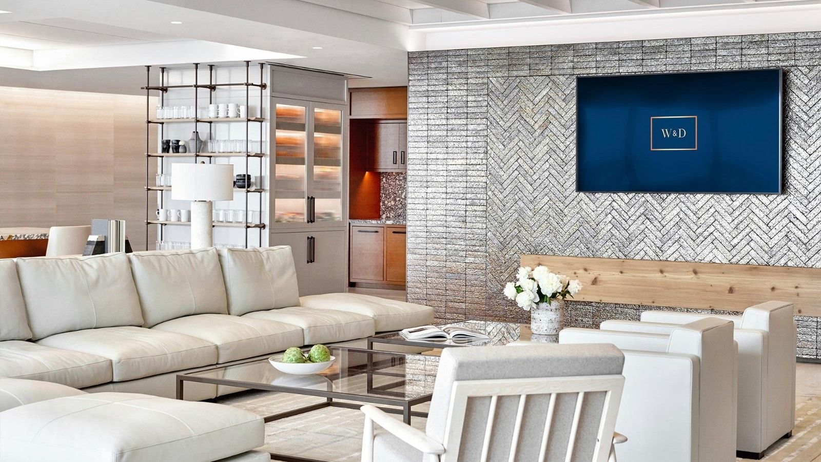 Walker & Dunlop: A living room with white sofas, a herringbone tile wall and a screen