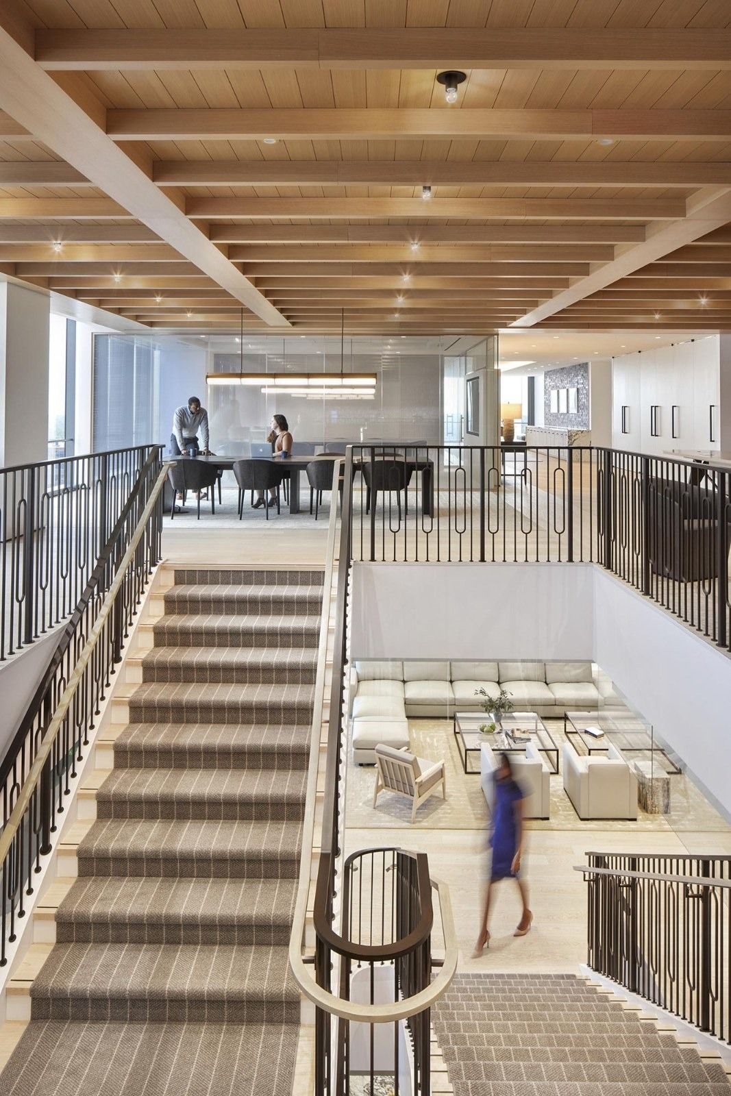 Walker & Dunlop: A wide stair descending to a lounge below with a picketed railing