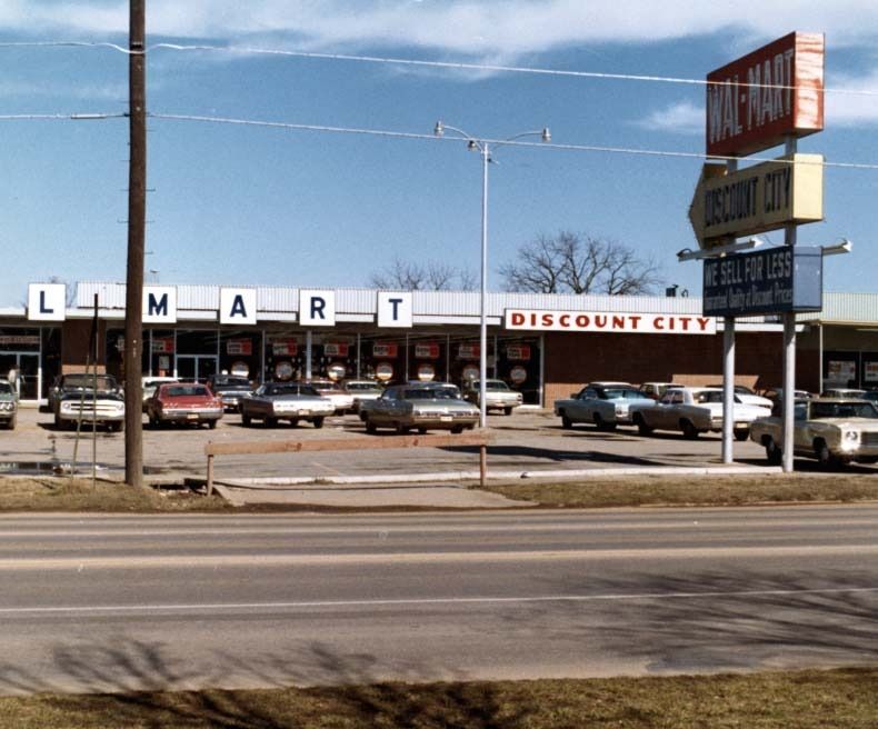Low store building with a Walmart sign beside a road