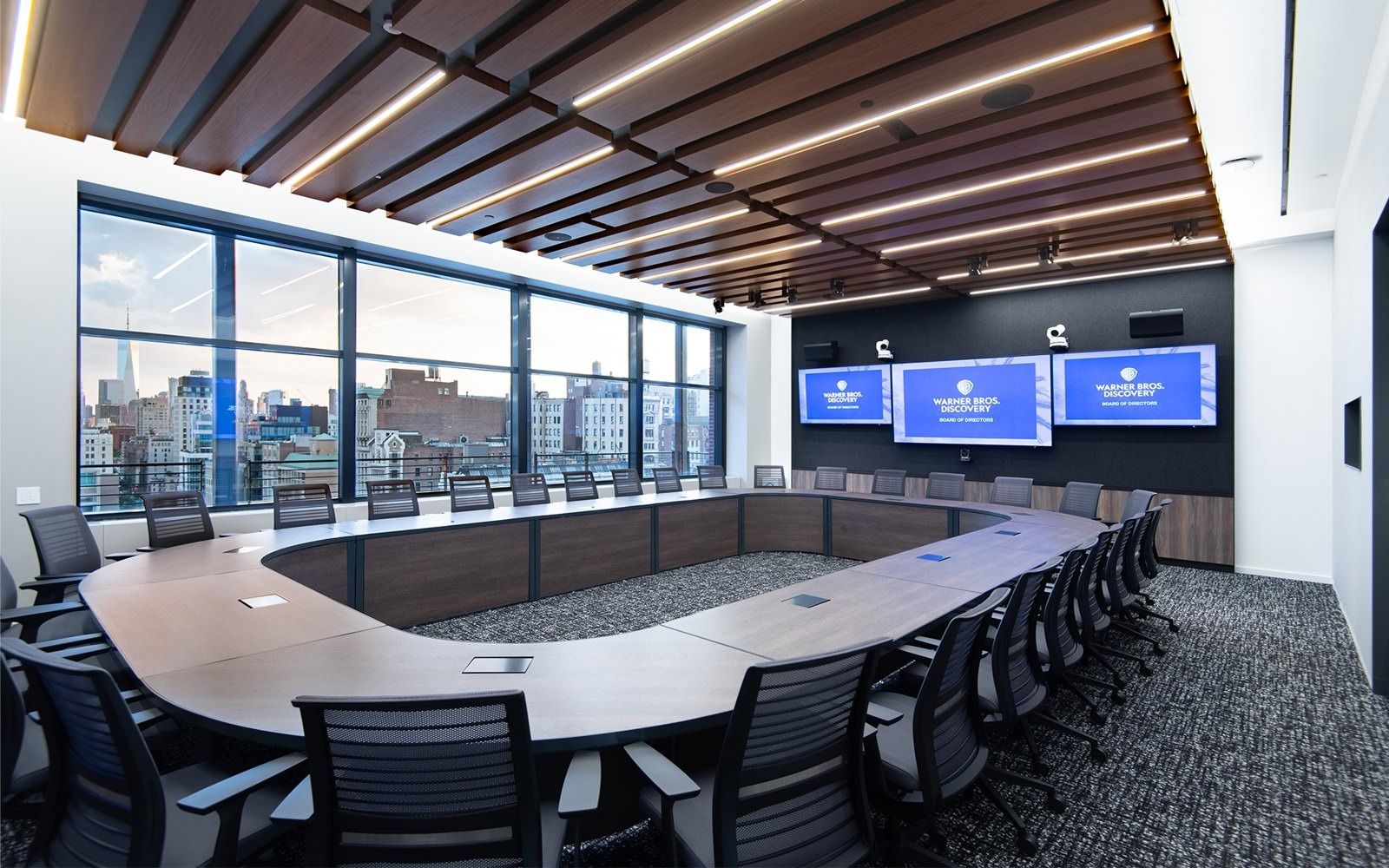Warner Bros. Discovery: Boardroom with an oval table and wall screens