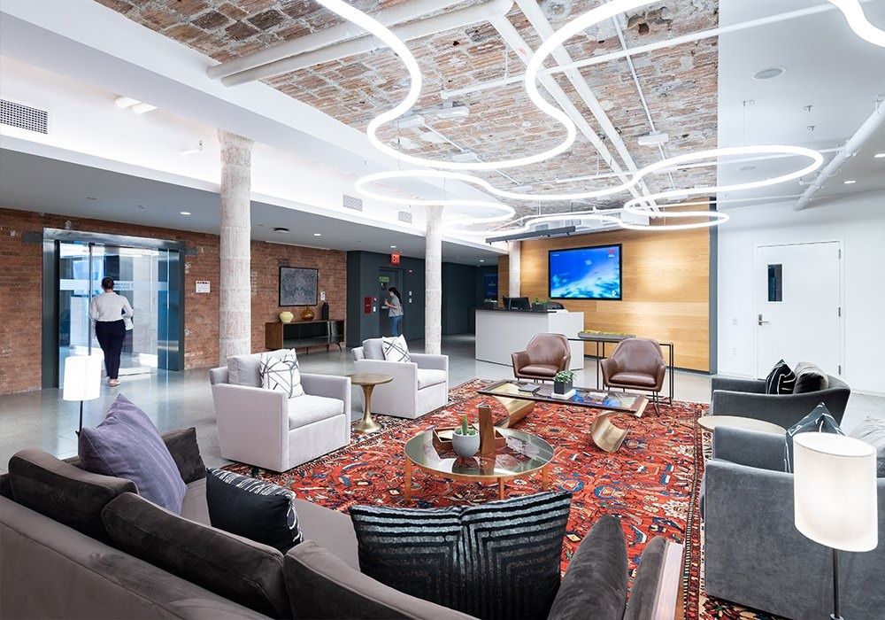 Warner Bros. Discovery: Sky lobby with sofas, a rug and circular light rings