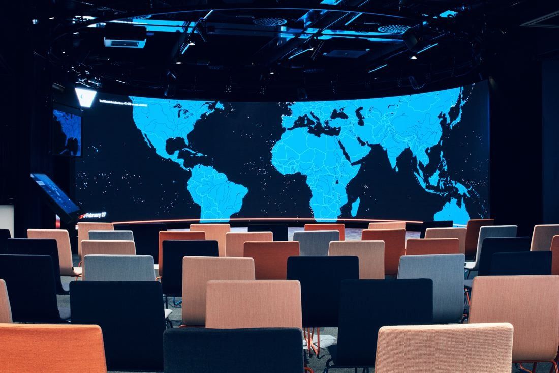 Wärtsilä: Rows of navy and pink chairs facing a large screen with a blue world map in a dark room