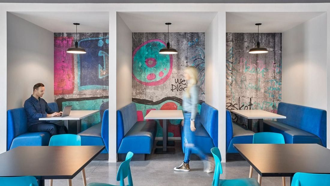 Wayfair: Blue booths in white alcoves with colourful graphic wall murals and pendant lamps