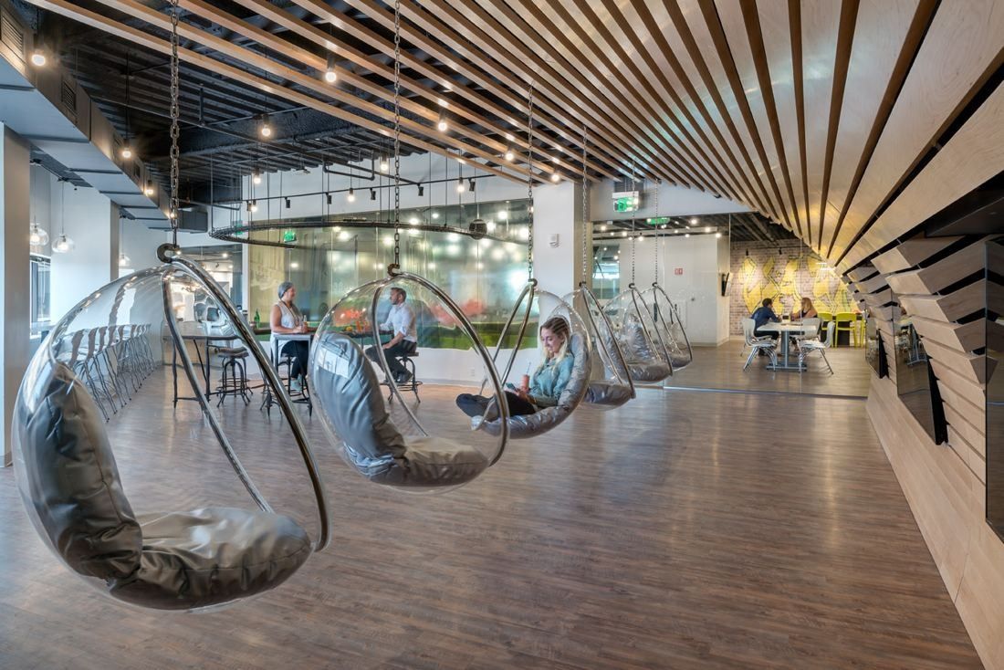 Wayfair: Long corridor with clear hanging bubble chairs under a wooden slat ceiling