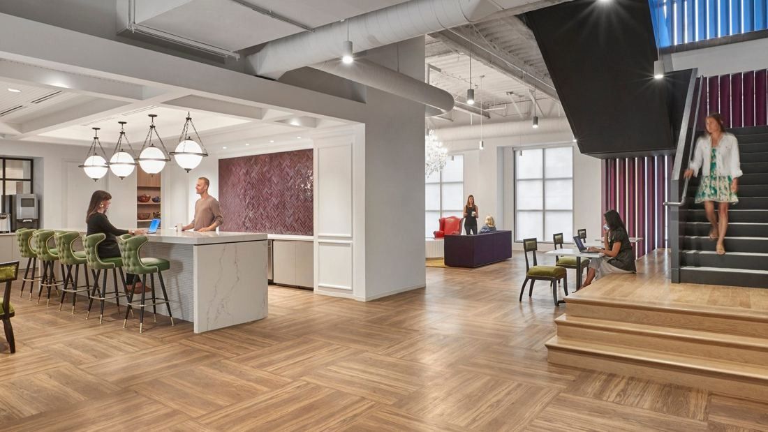 Wayfair: Open-plan café area with a kitchen island and pendant lights, and a wide wooden stair with seating steps