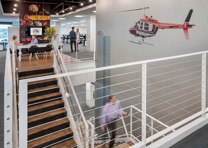 Wayfair: Stairwell with white cable railings and a model helicopter hung on the wall above