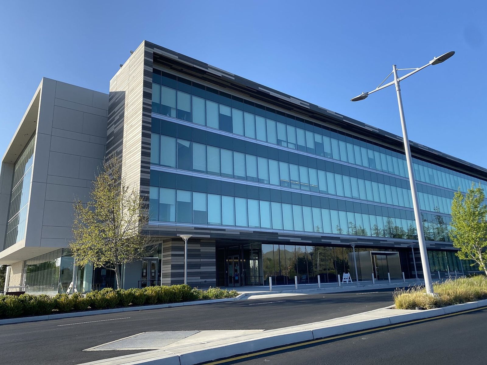 Western Digital: A long glass office building with a white wing and a street lamp in front